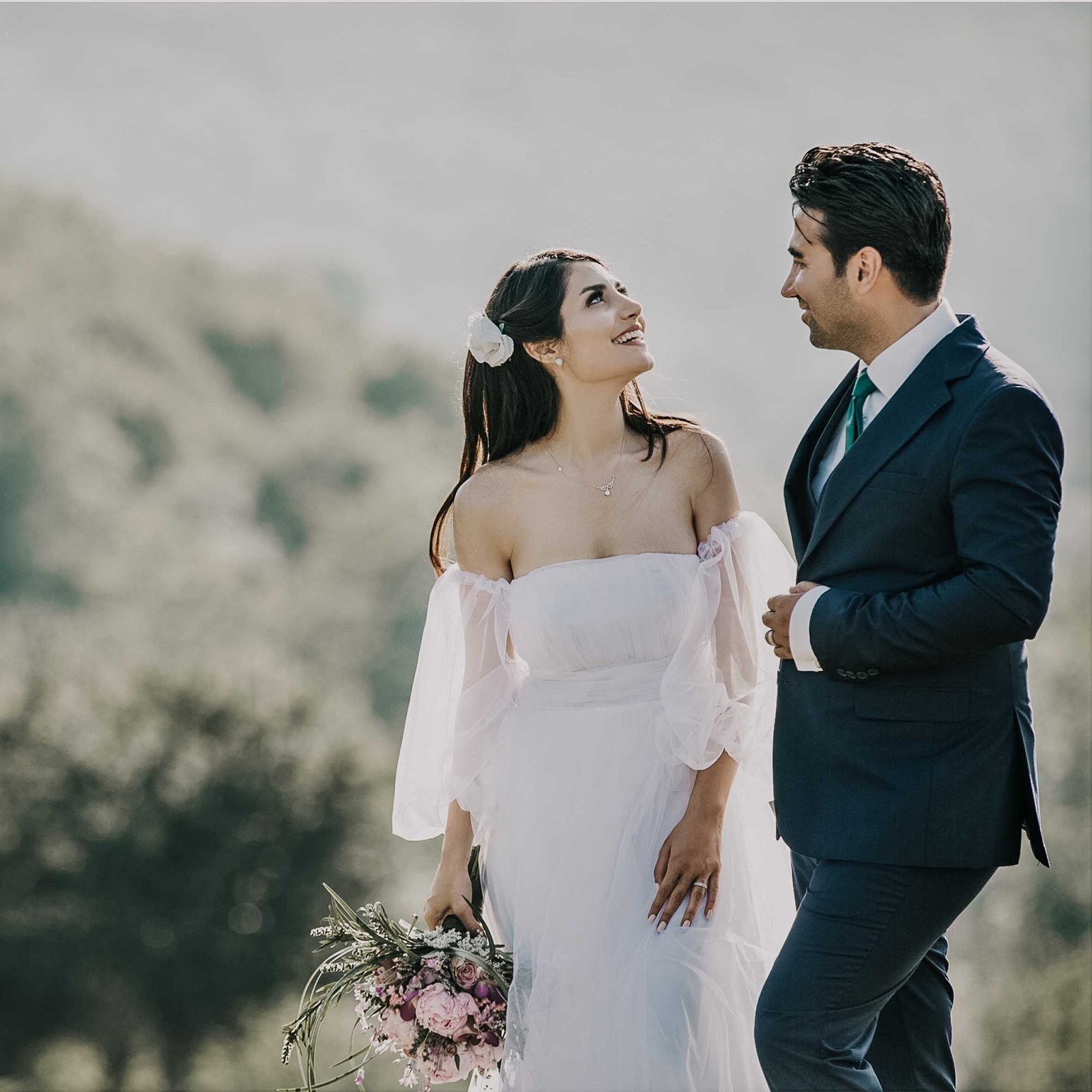 Bahçede düğün kutlaması yapan gelin, damat ve misafirler